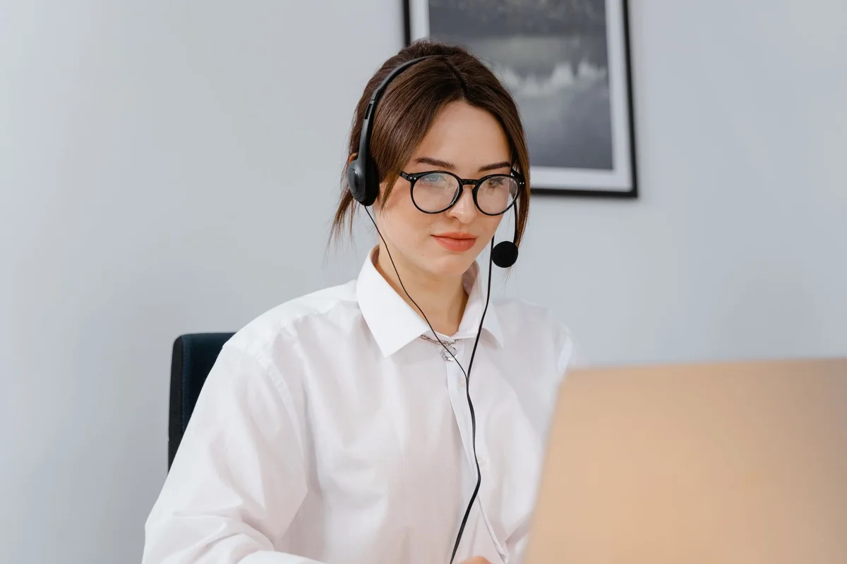 Customer support professional wearing a headset and working at a laptop