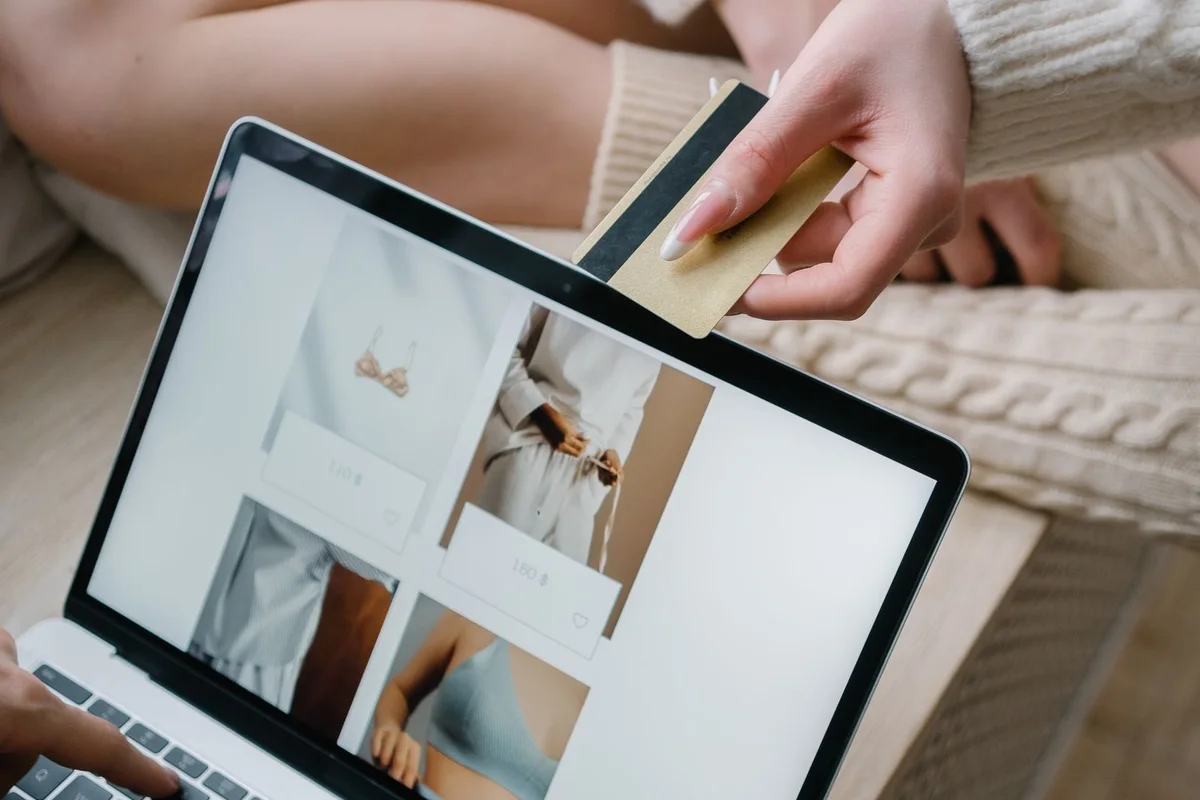 People browsing an online store on a laptop with a payment card