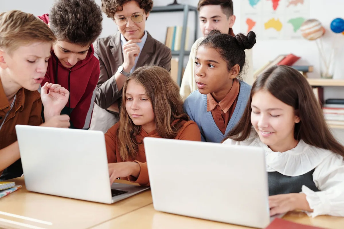 School students learning together with a laptop in a classroom